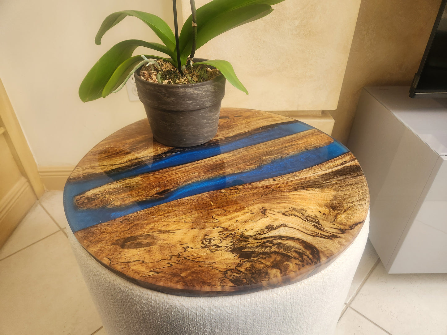 Natural wood and epoxy side table.  With blue inlay, 20 inches round with black pin legs